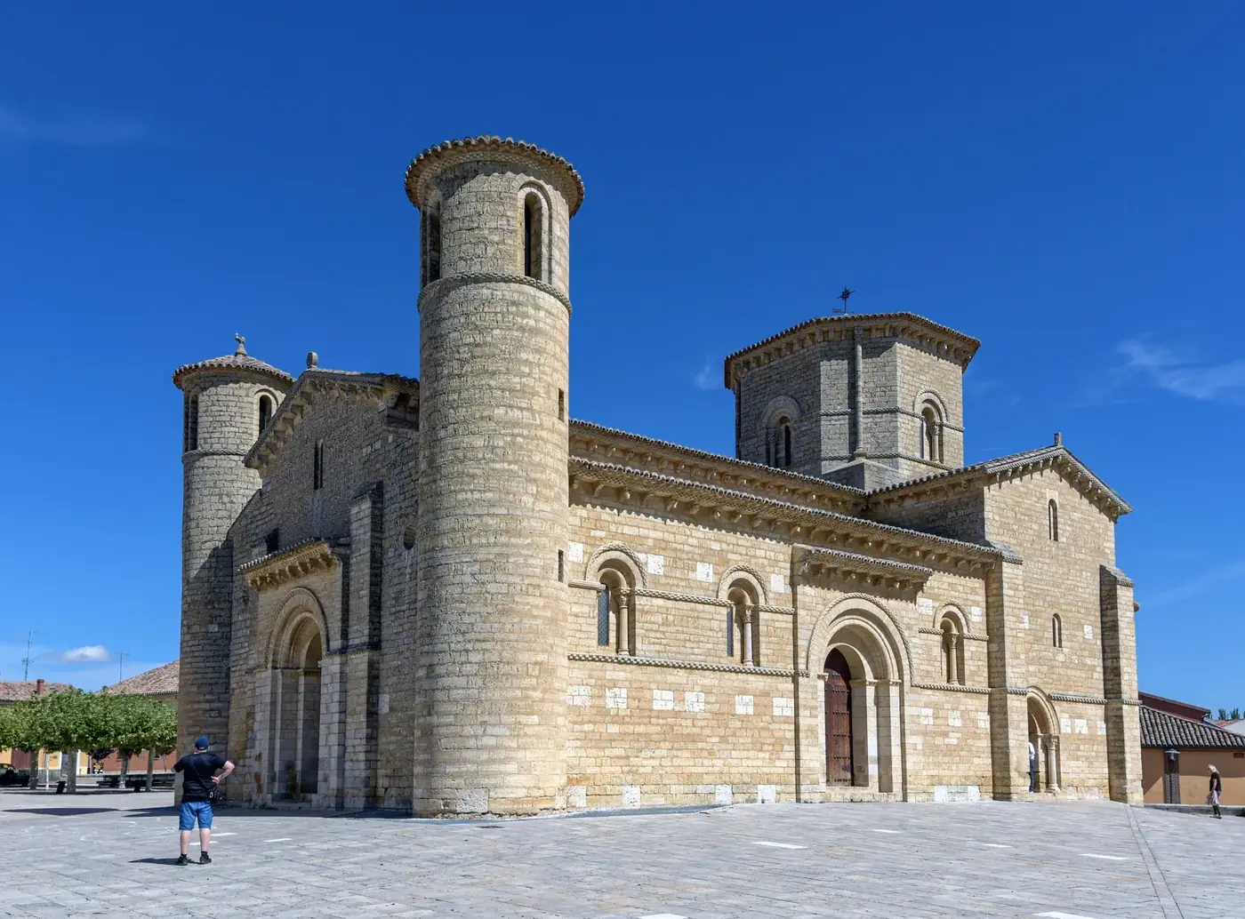 Romantic Romanesque church in Frómista, Spain, under a vibrant blue sky.