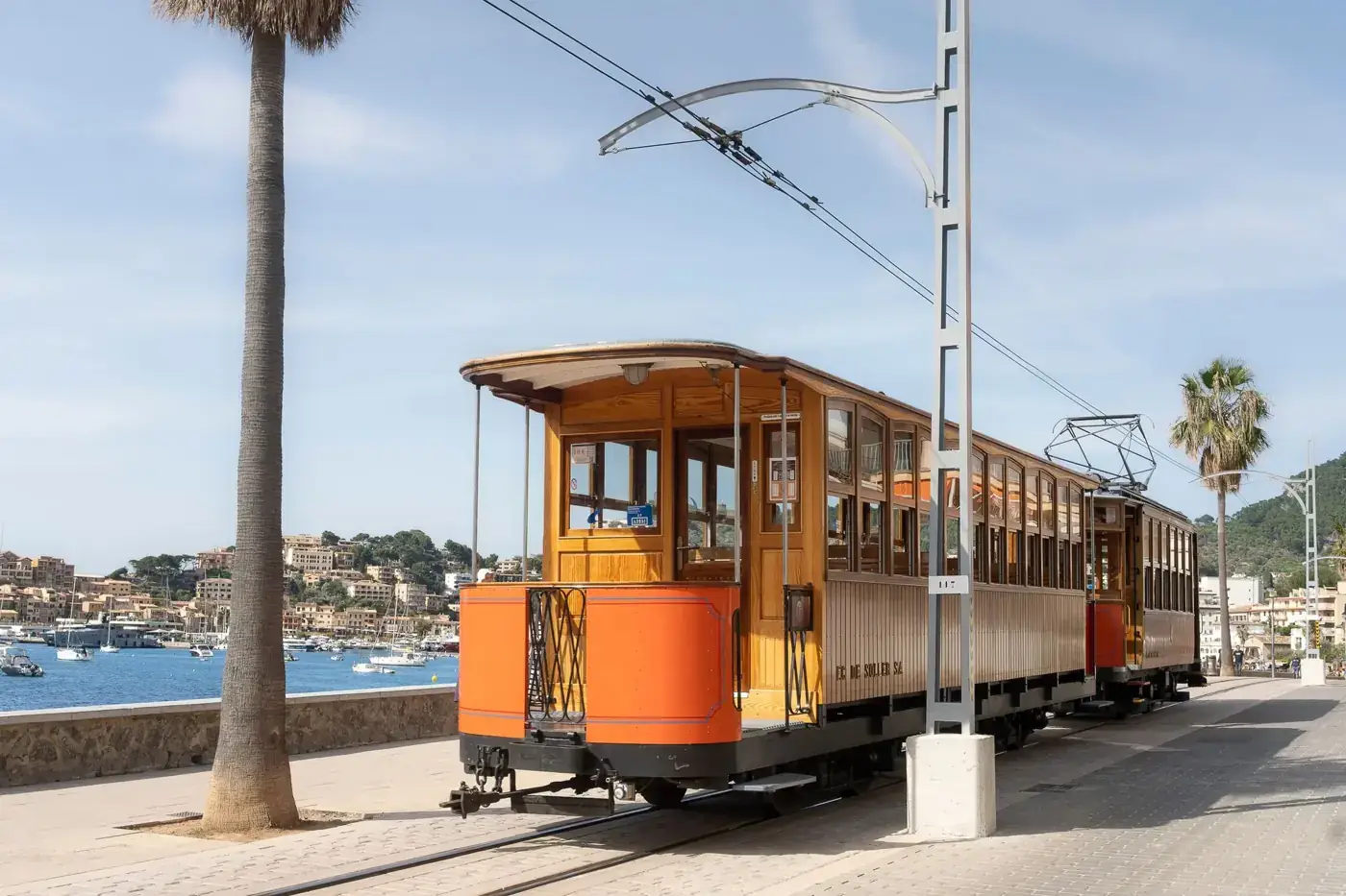 A vintage tram travels along the scenic waterfront in Port de Sóller, Mallorca.