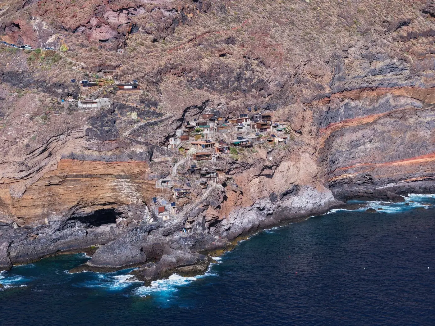 Scenic aerial shot of a rugged coastal village built into cliffs in La Palma, Murcia.
