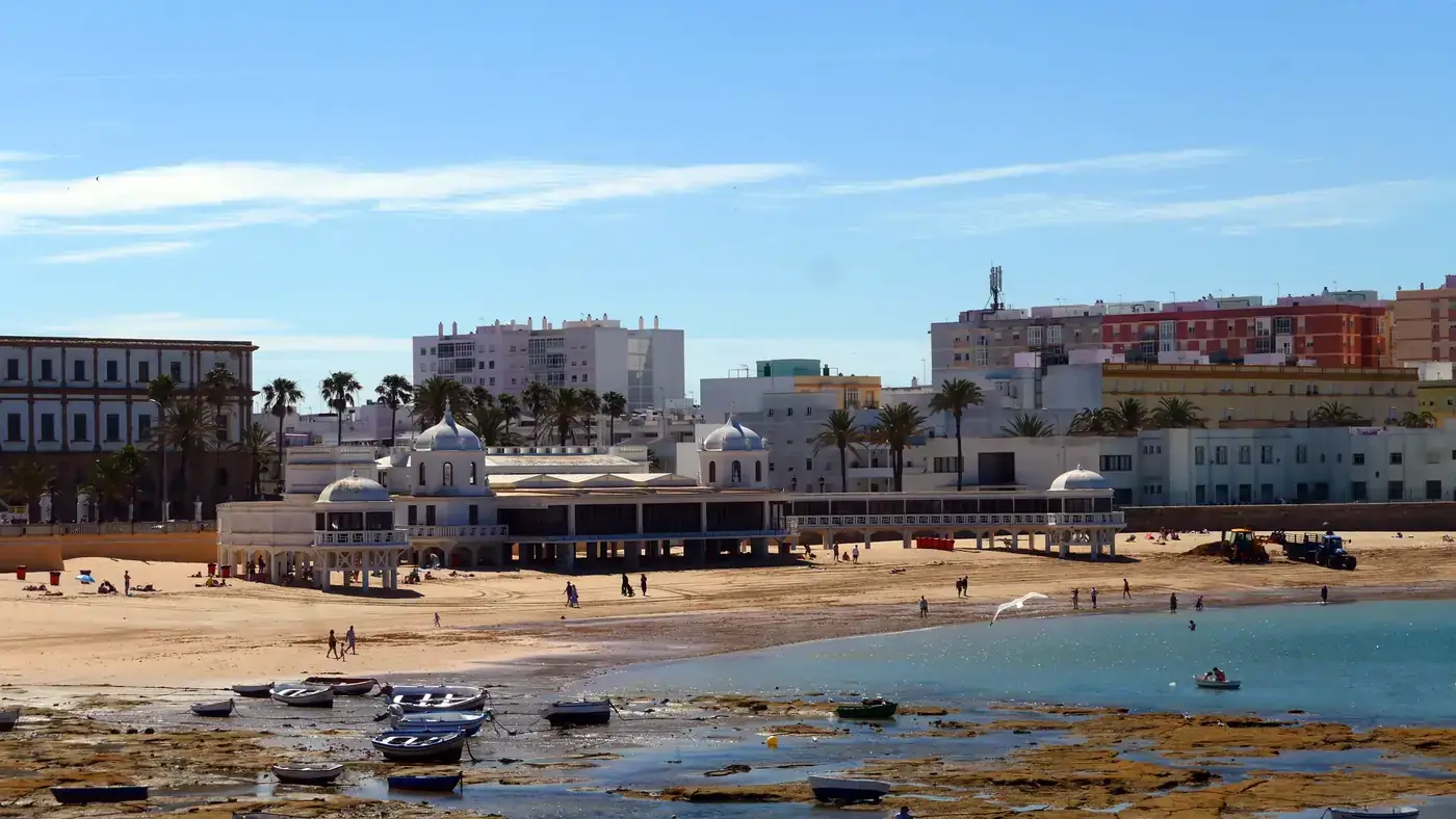 Scenic daytime view of La Caleta beach with historic bathhouse in Cádiz, Andalusia, Spain.