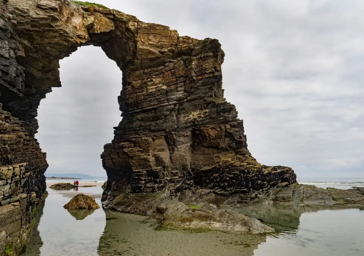 A captivating view of the natural stone arch at Cathedral Beach in Galicia, Spain.