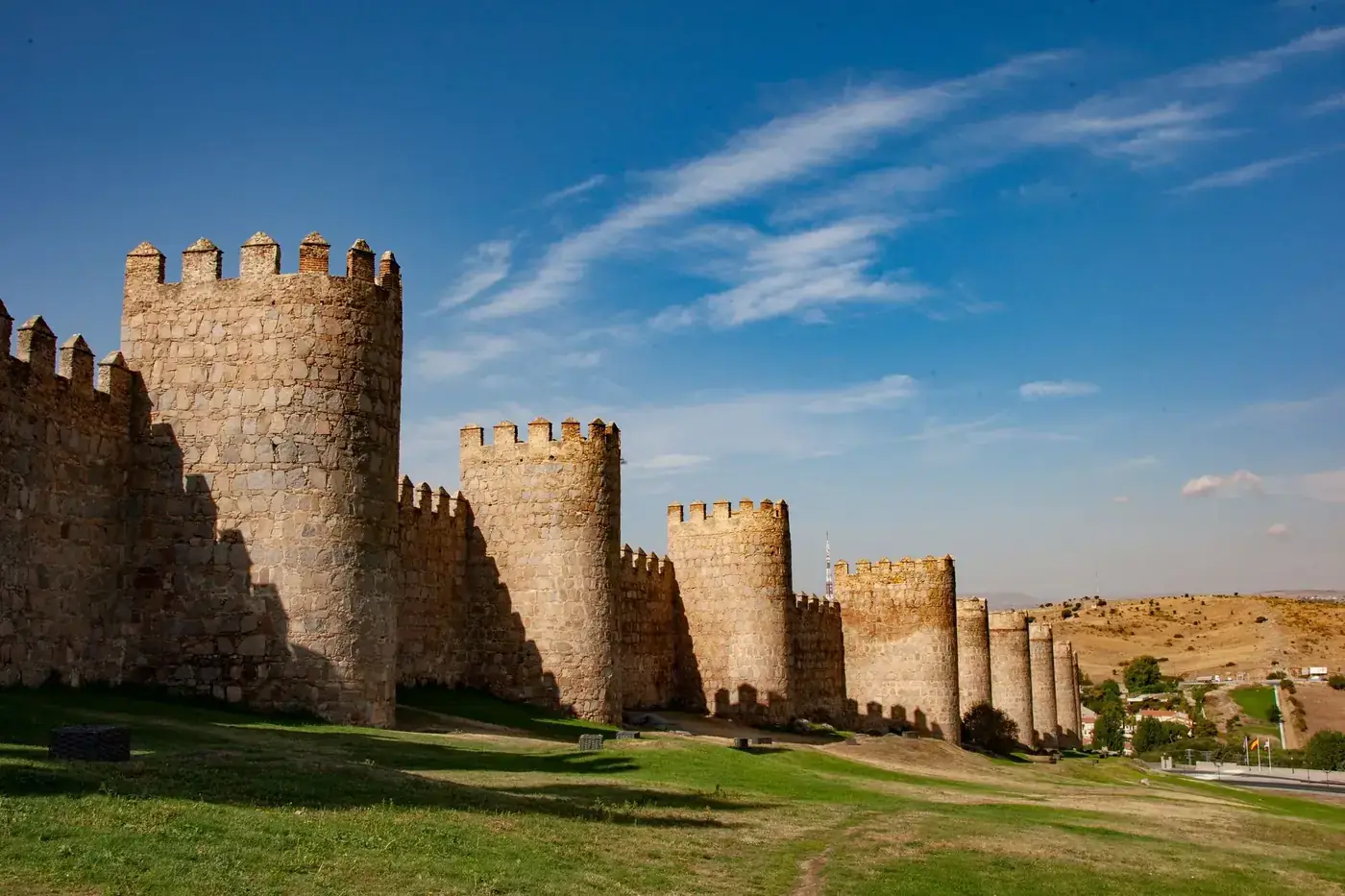 Explore the historic stone walls of Ávila on a sunny day in Spain.