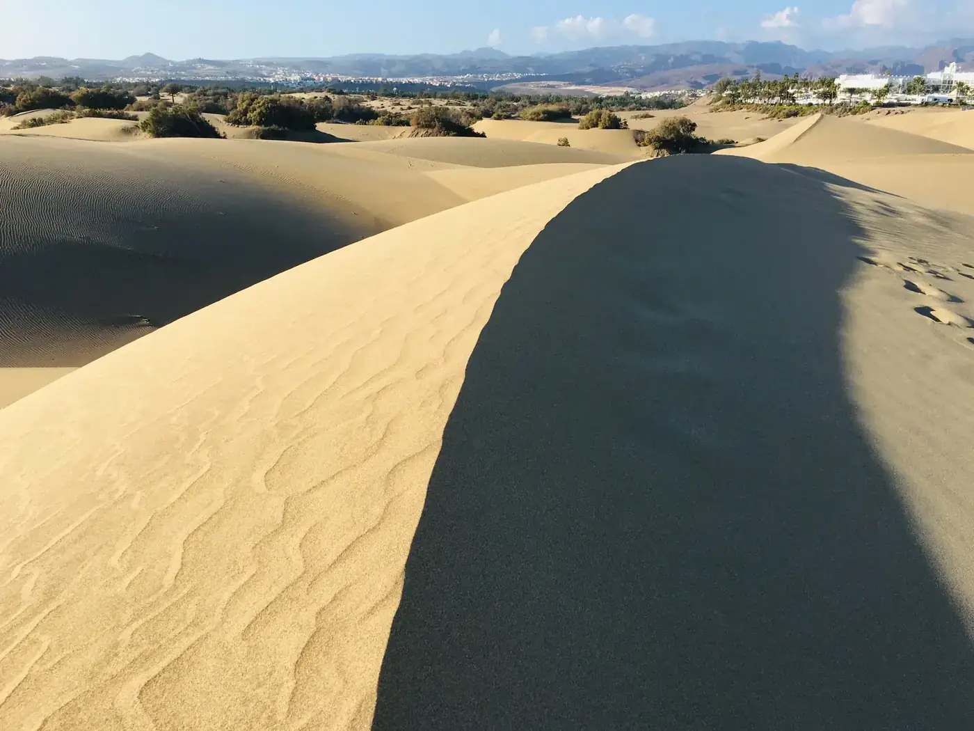 Stunning view of the Maspalomas sand dunes in Gran Canaria under a clear blue sky.