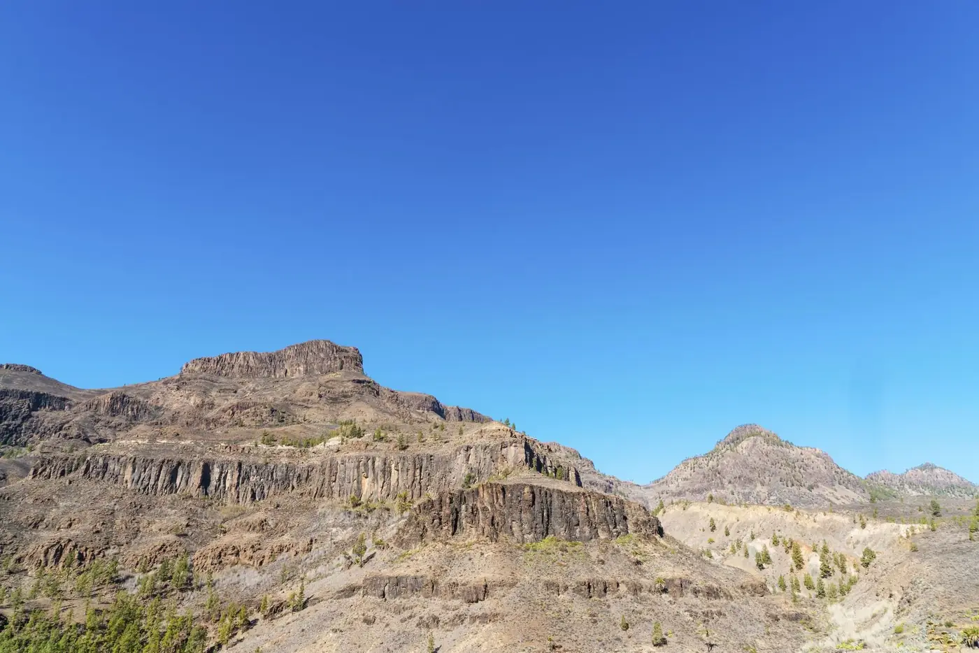 Stunning view of Grand Canyon-like rock formations against a bright blue sky, perfect for travel and nature enthusiasts.