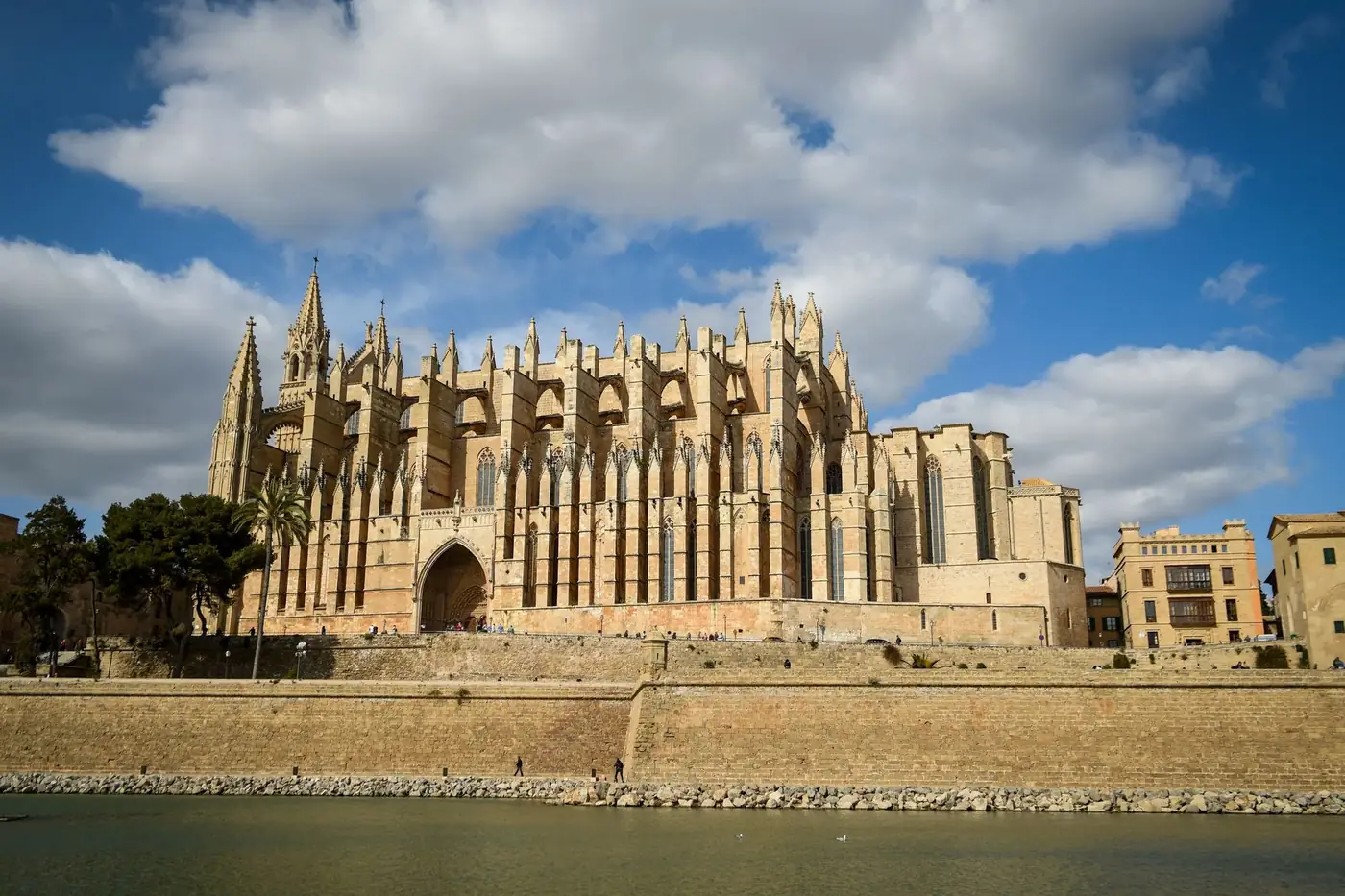 The majestic Gothic La Seu Cathedral in Palma de Mallorca against a bright blue sky.
