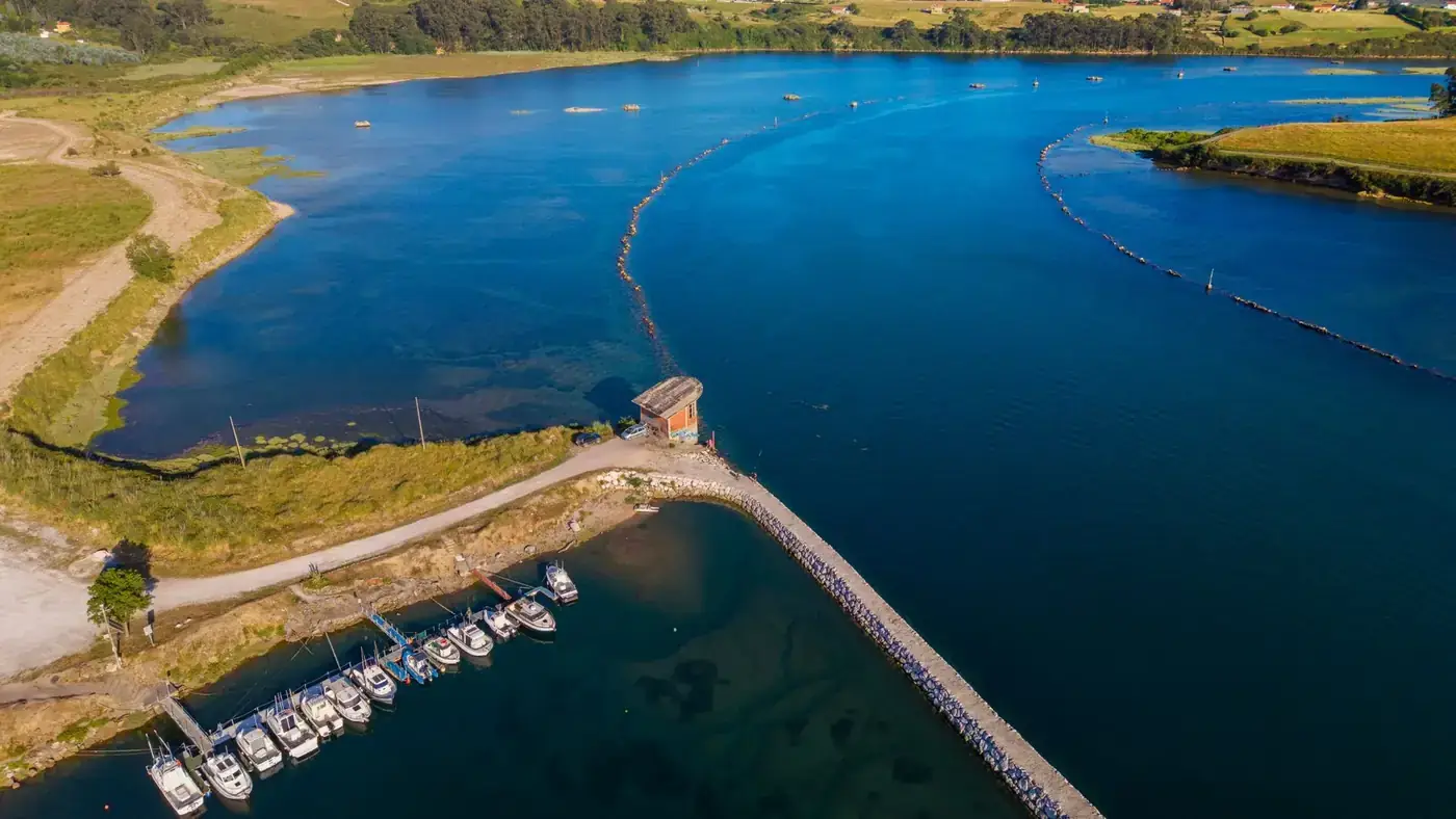 Scenic aerial shot of a tranquil bay with a dock and boats, showcasing natural beauty and vibrant colors.