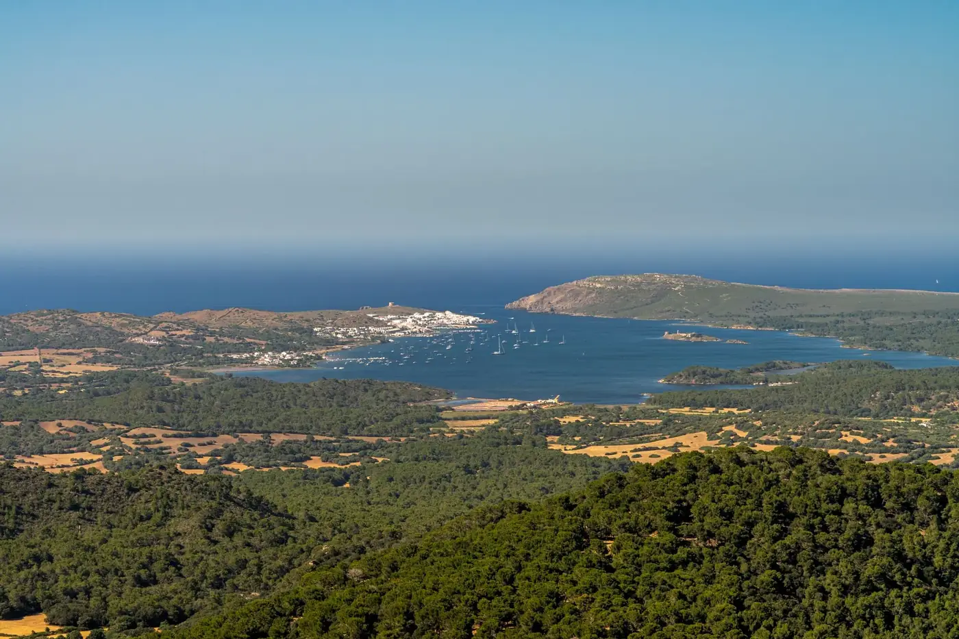 Breathtaking aerial view of Ciutadella, Islas Baleares, showcasing the Mediterranean Sea and lush landscapes.