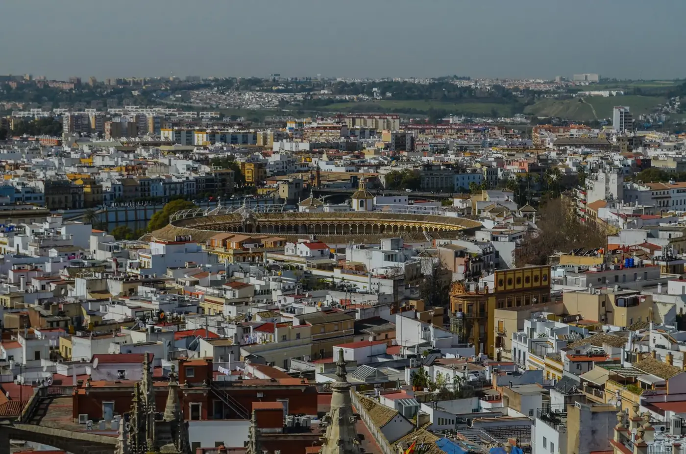 A stunning aerial view of Seville showcasing the iconic bullring and surrounding historic architecture.
