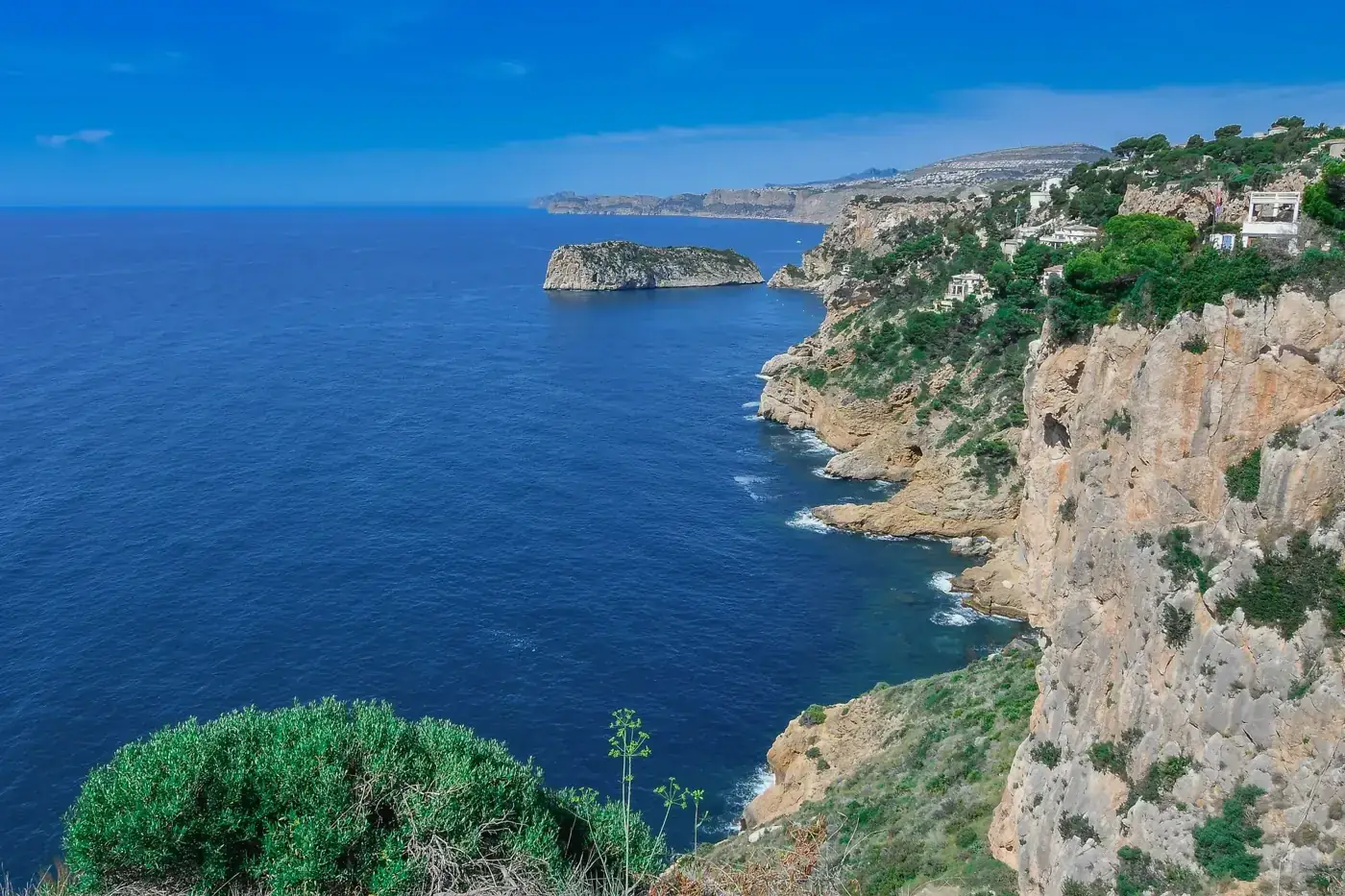 A breathtaking view of the rugged coastal cliffs and blue sea in Jávea, Spain.