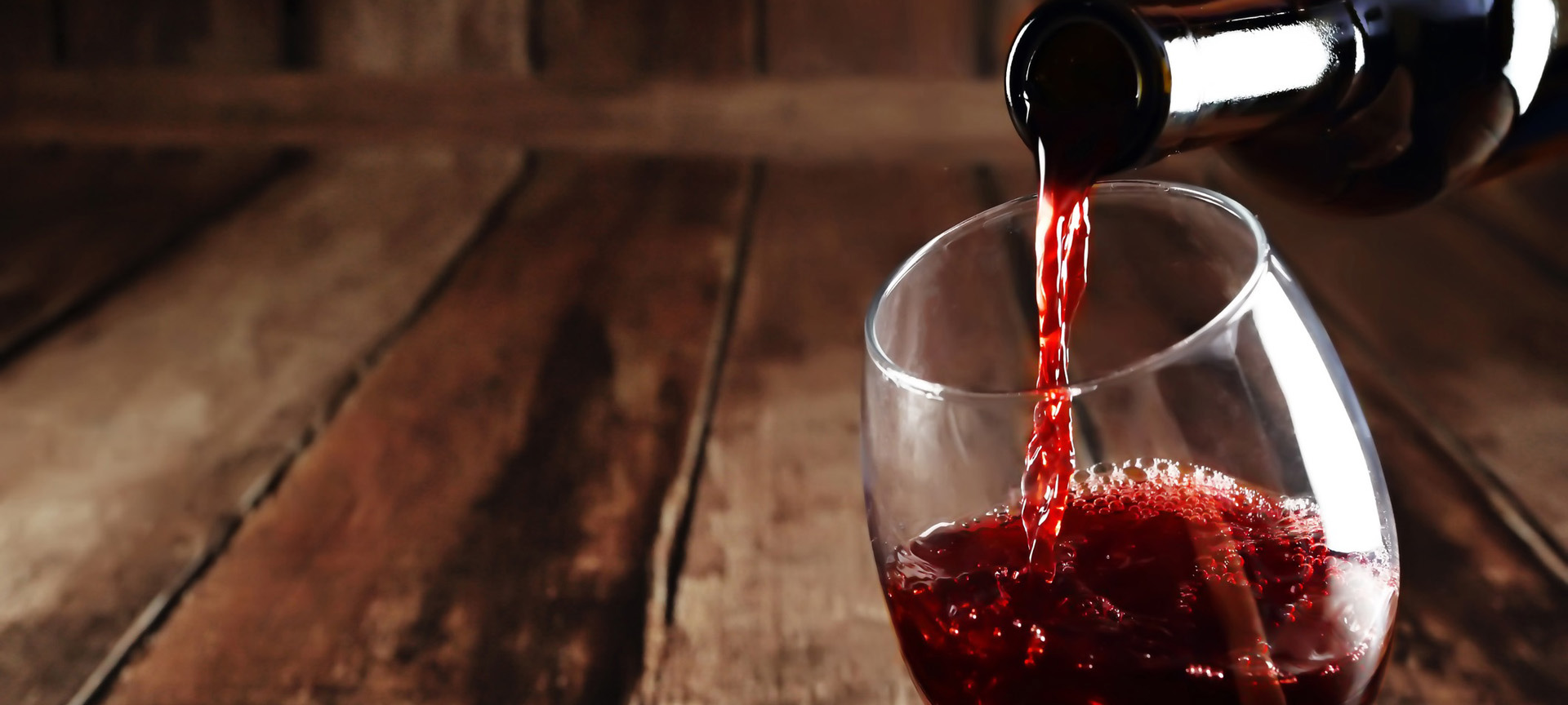 Rode wijn inschenken in glas.