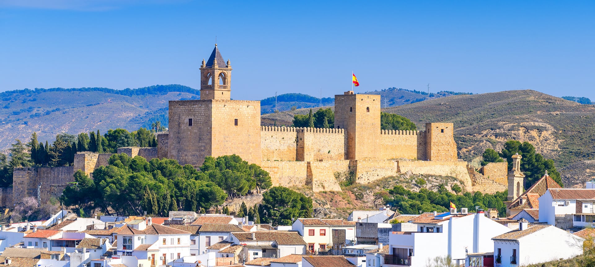 Historisch kasteel boven Spaanse stad met huizen en heuvels.