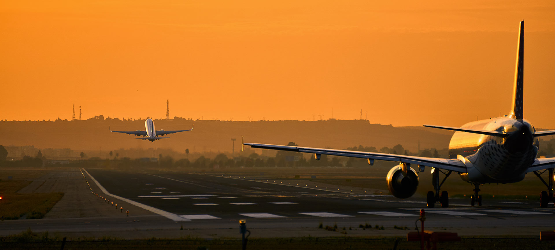 Vliegtuigen op startbaan bij zonsondergang.