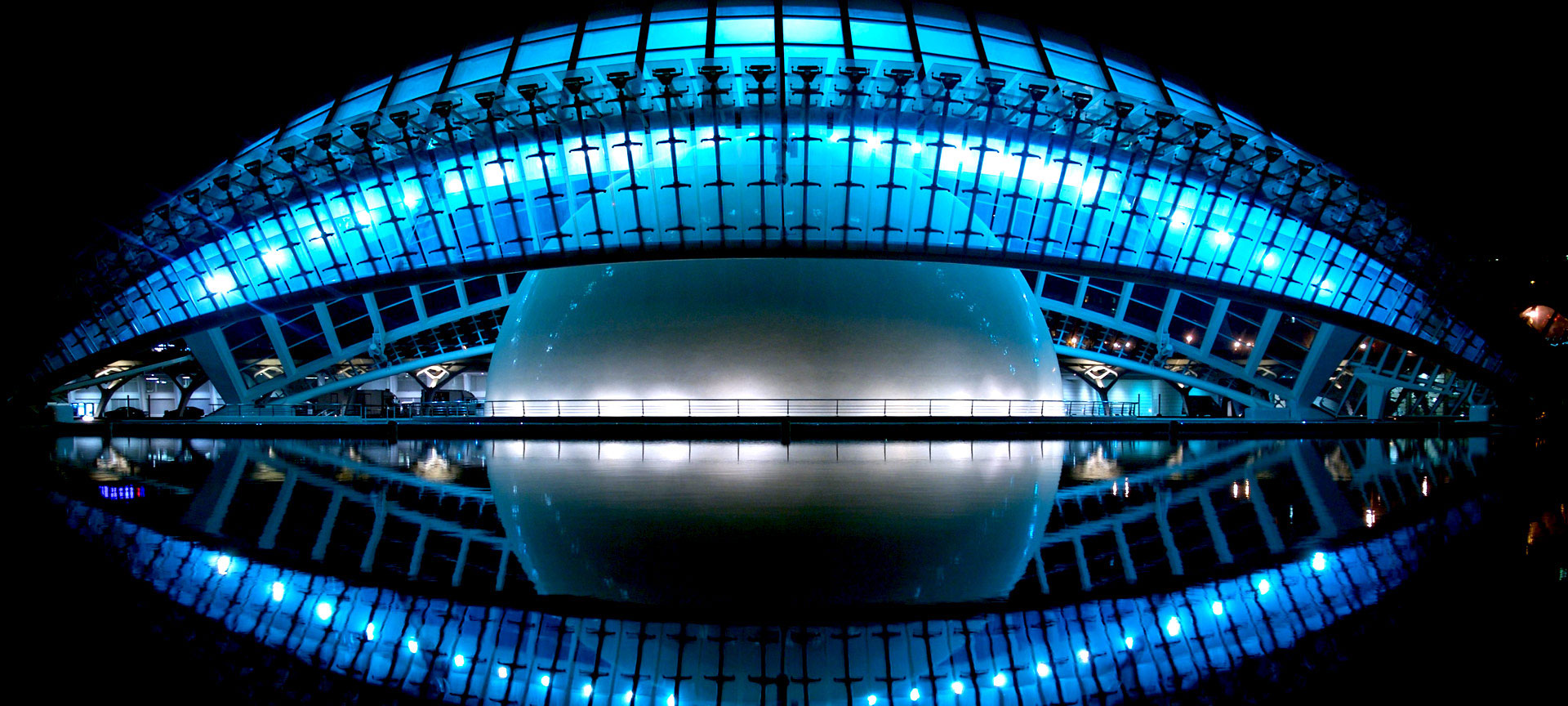 Moderne architectuur met blauwe verlichting en reflectie in water.