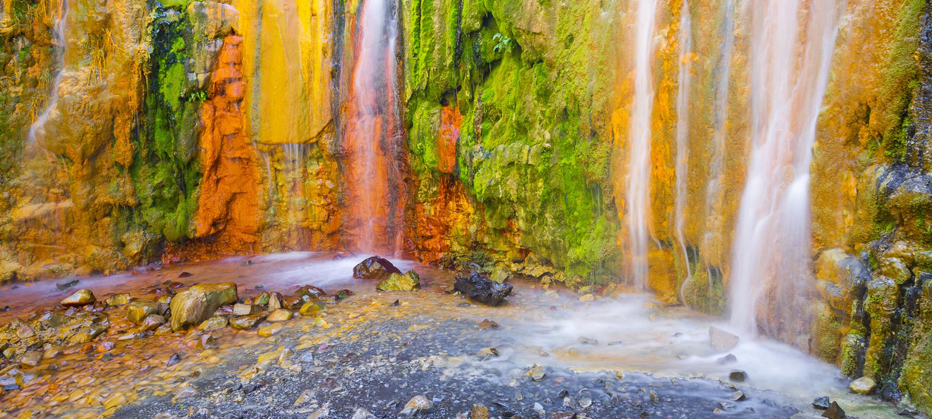 Kleurrijke mineraalrijke waterval met mos.