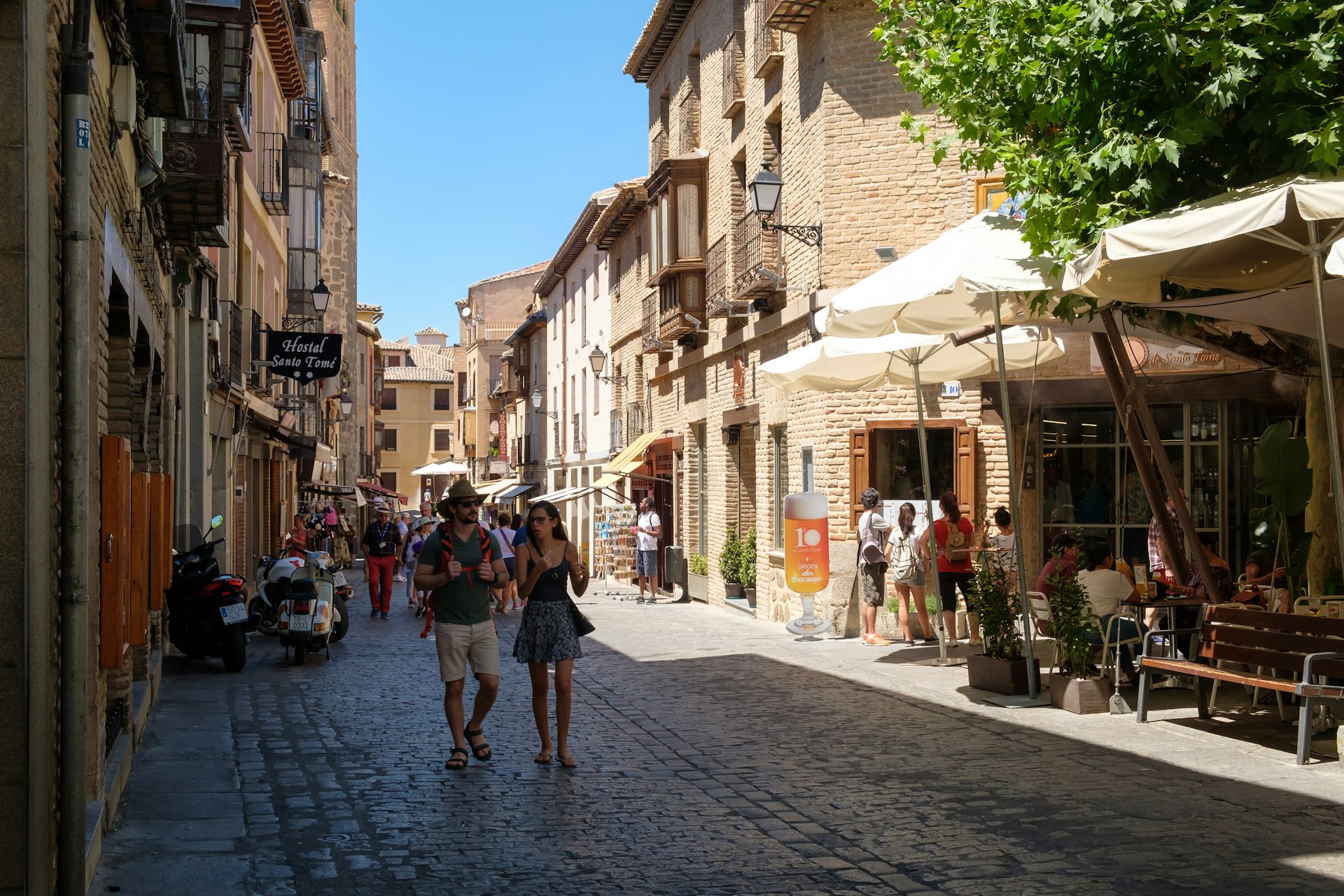 Mensen lopen door een geplaveide straat in de middeleeuwse stad Toledo