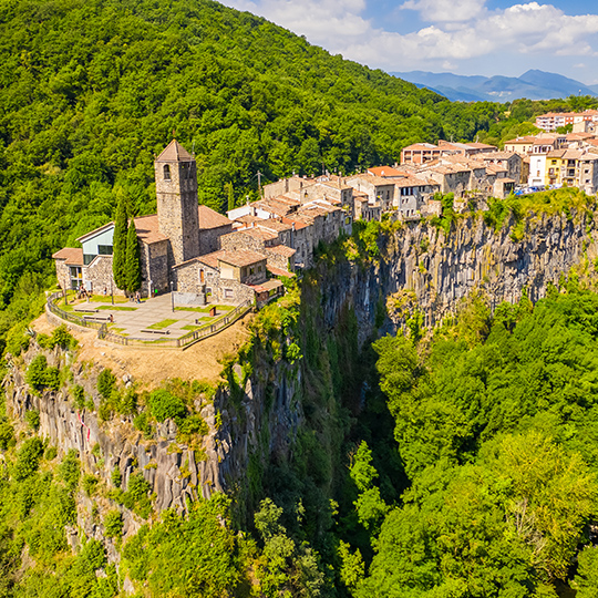 Luchtfoto van het kleine dorpje CastellFollit de la Roca op 50 meter hoogte in het natuurreservaat Garrotxa vulkanische zone, Catalonië