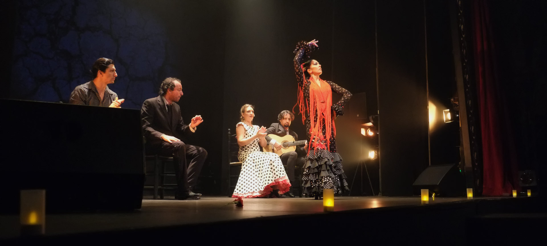 Flamencodans en muzikanten op podium.