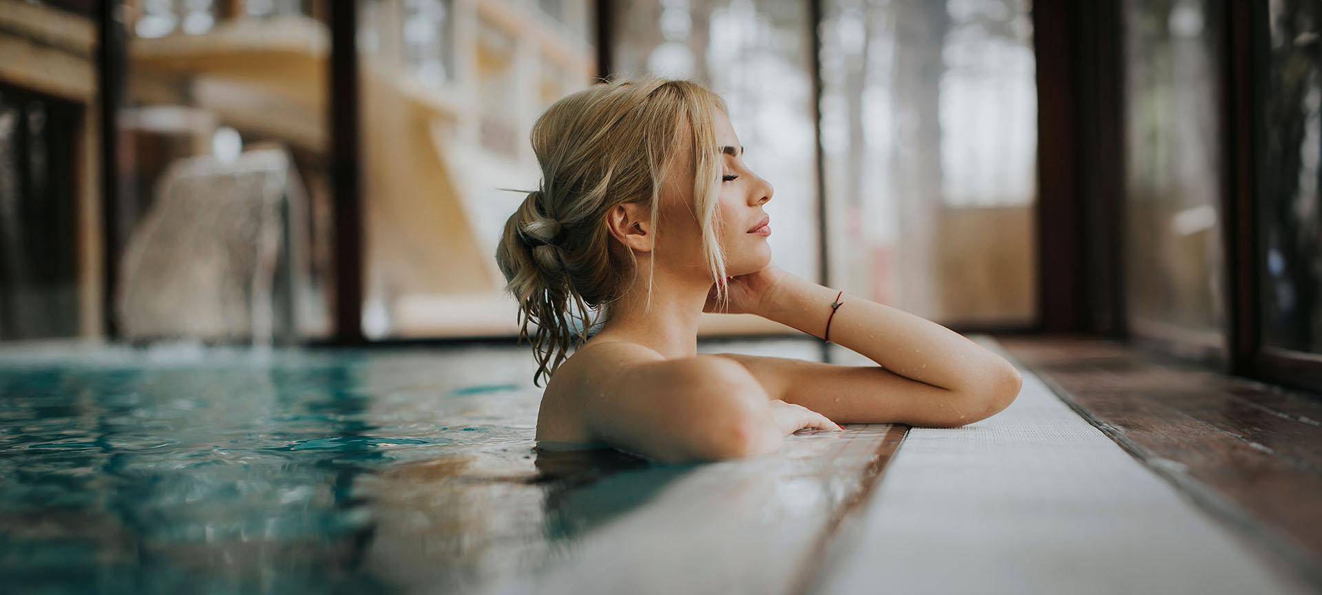 Vrouw ontspant in zwembad binnen spa.