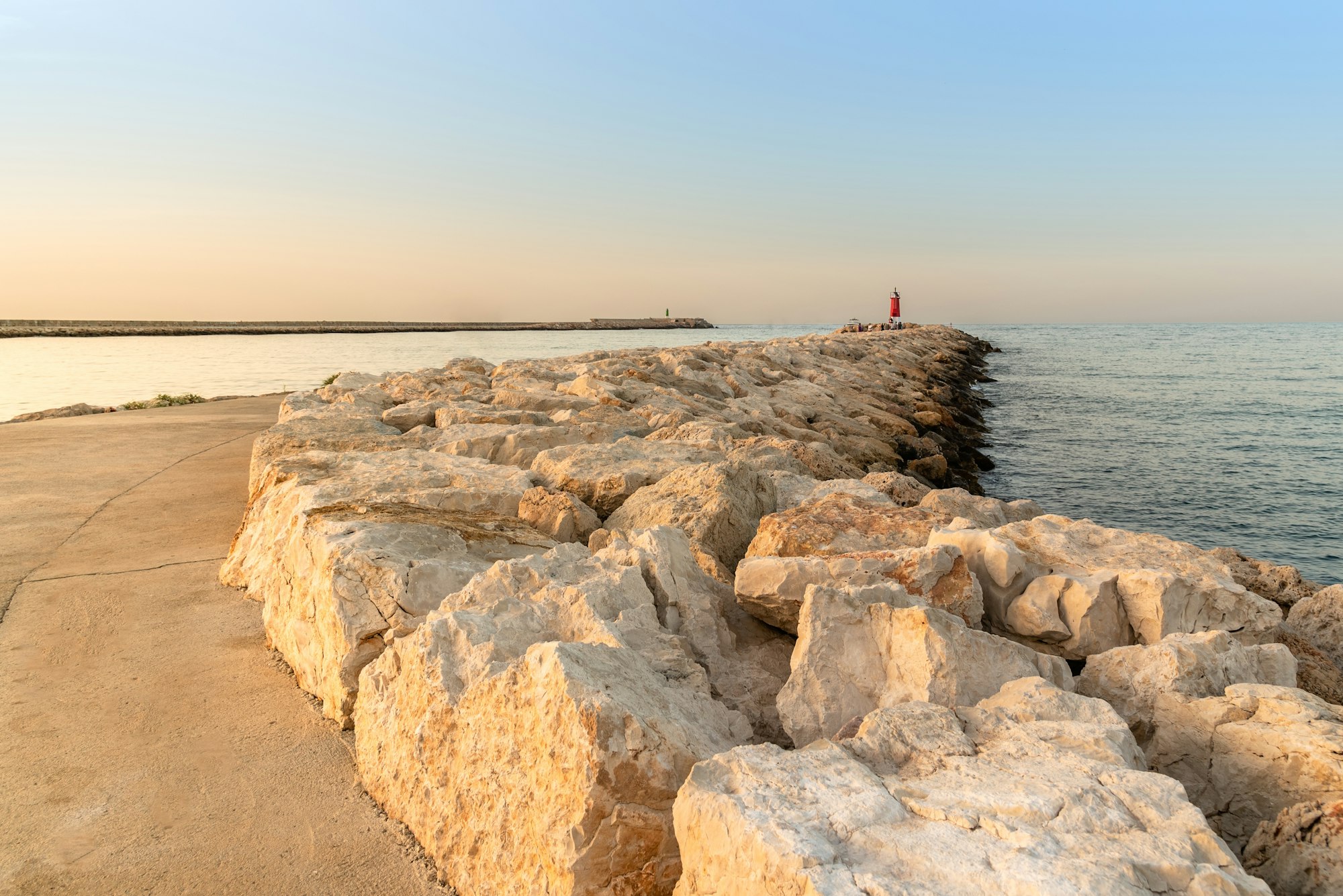 Beautiful summer sunset on the harbour breakwater. Denia, Alicante, Spain.